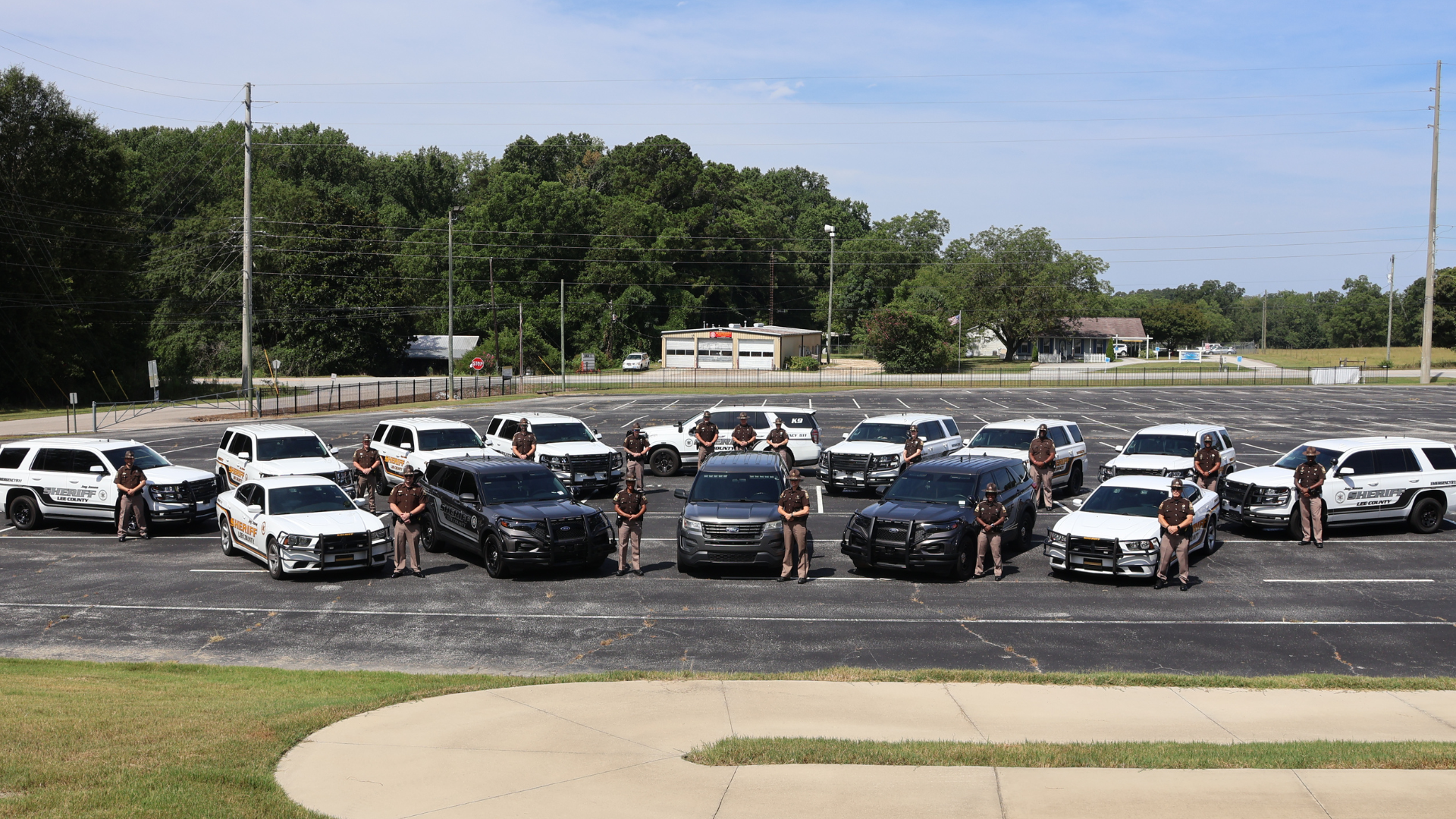 Deputies standing with their patrol vehicles in a parking lot